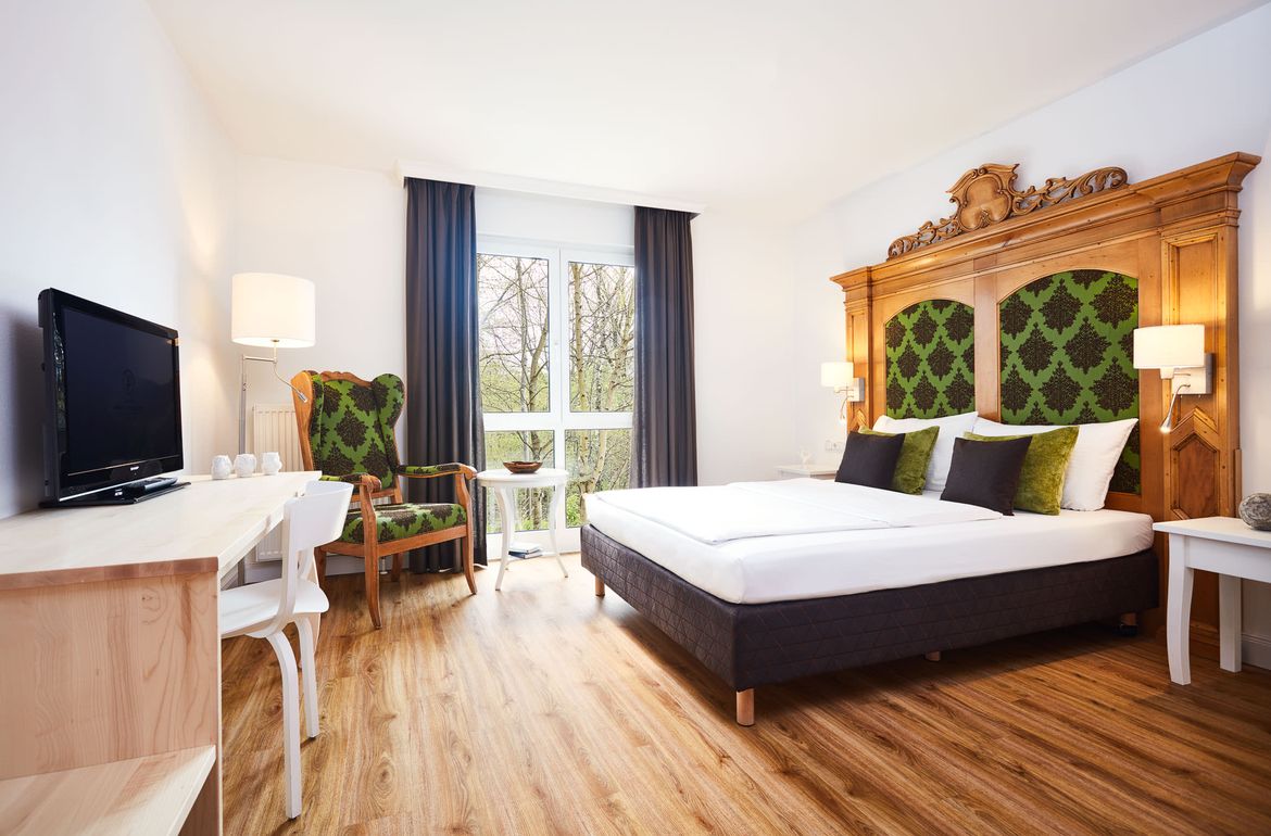 Teaserbild Premiumzimmer grün mit großem Bett & TV Hotel Prinzregent